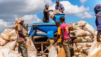 African farm workers using tractor powered shelling machine